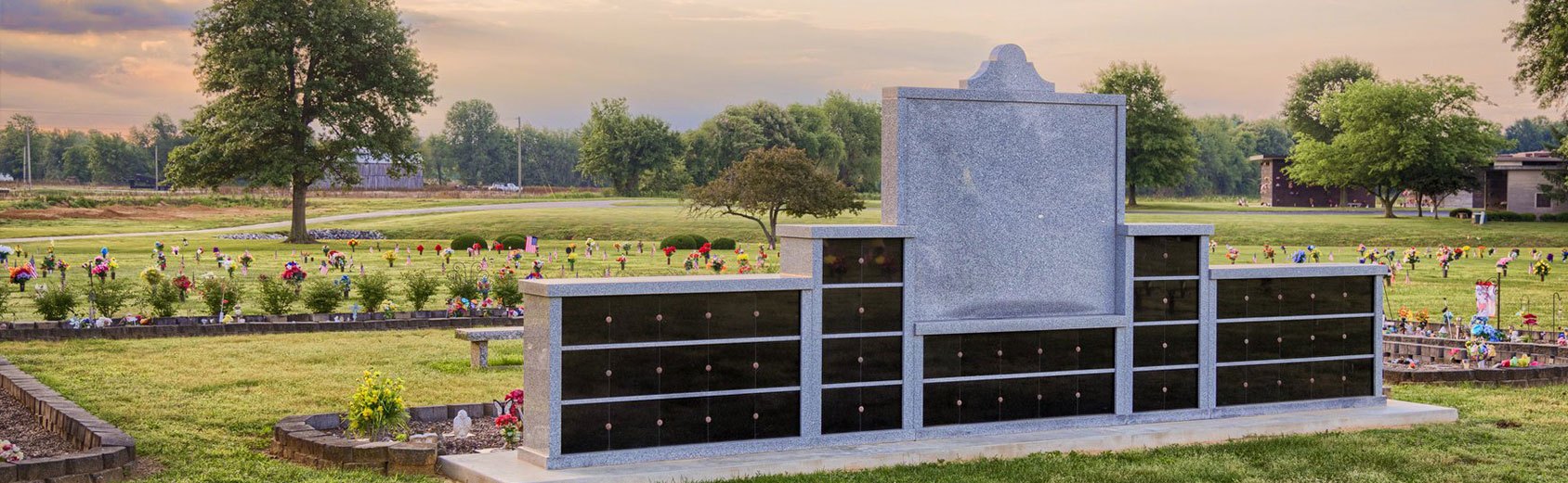 Sunset behind a planned resting place for ashes in a cemetery